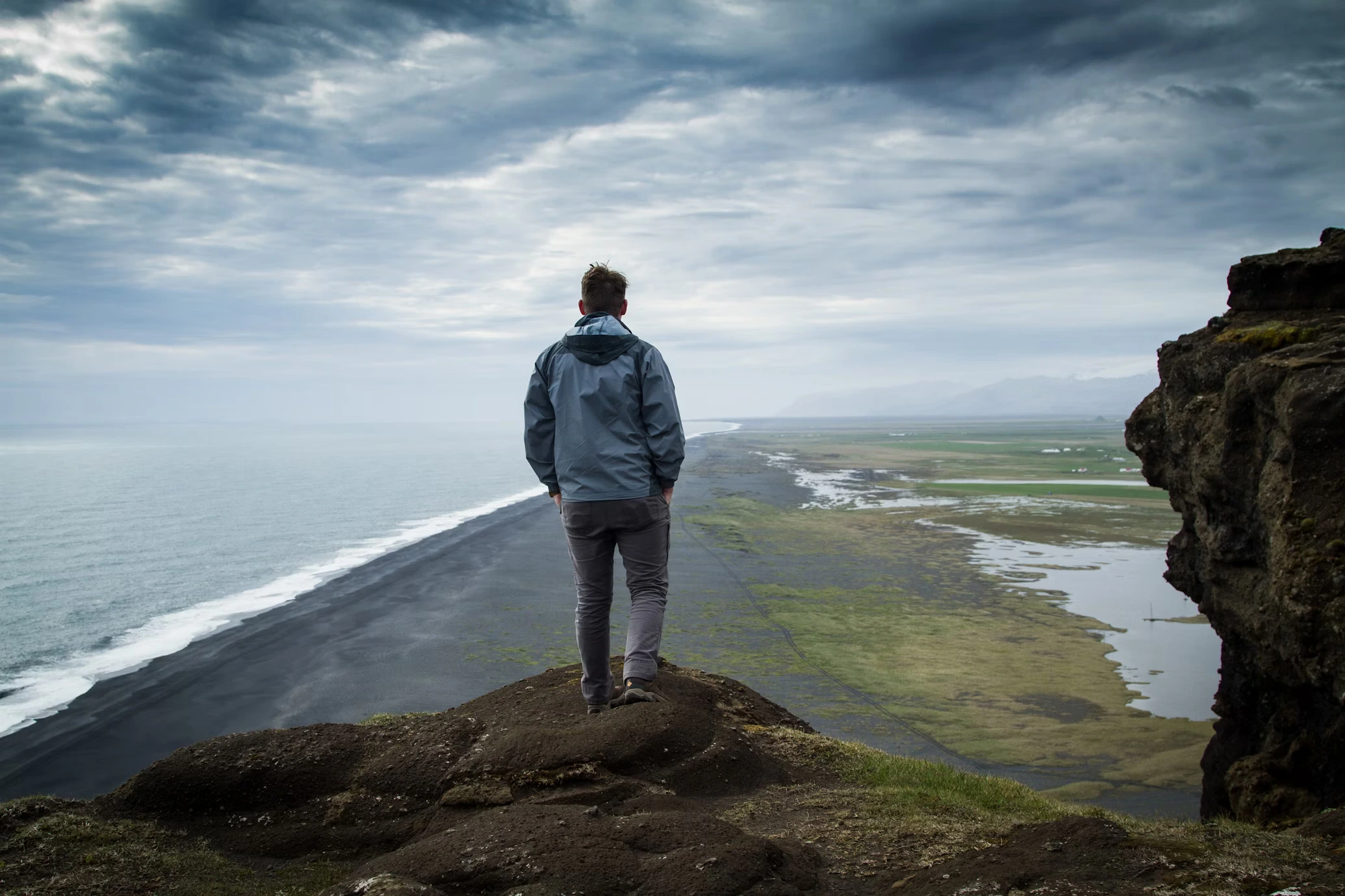 A man up on the top of a hill looking into the distance